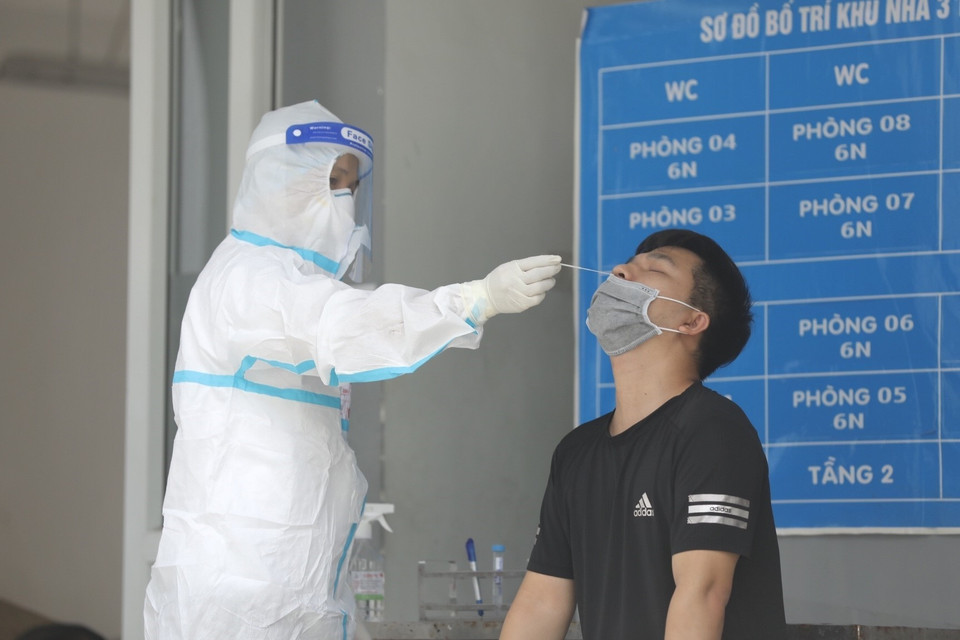 Nhân viên y tế quận Tây Hồ lấy mẫu xét nghiệm COVID-19 cho người thực hiện cách ly. (Ảnh: Minh Quyết/TTXVN)