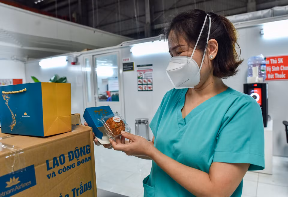 Các y bác sĩ tại Bệnh viện dã chiến bất ngờ và thích thú khi nhận được những món quà mang đậm không khí Tết đoàn viên cùng những lời chúc tốt đẹp đã vượt hơn 1.300 cây số để đến tận tay người nhận. (Ảnh: CTV/Vietnam+)