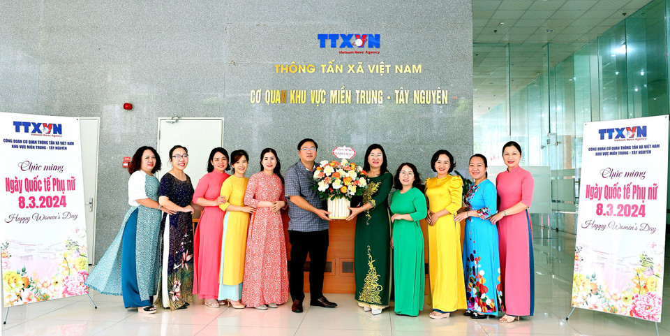 Lãnh đạo Cơ quan Đại diện TTXVN khu vực miền Trung-Tây Nguyên tặng hoa cho chị em phụ nữ. (Nguồn: TTXVN)