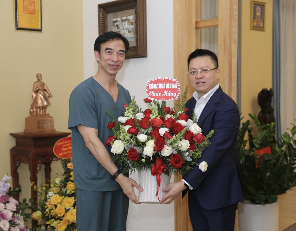 Ủy viên Trung ương Đảng, Phó Tổng Giám đốc TTXVN Lê Quốc Minh chúc mừng Giám đốc bệnh viện Bạch Mai Nguyễn Quang Tuấn nhân Ngày Thầy thuốc Việt Nam. (Ảnh: Hoàng Hiếu/TTXVN)