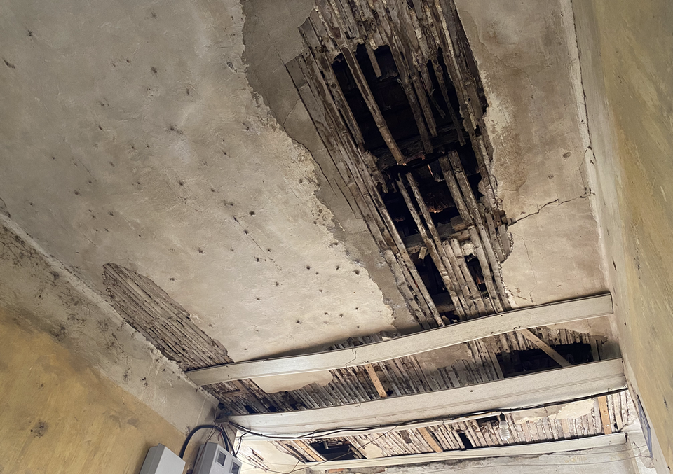 Một phần mái bị thủng còn nằm ngay trên hệ thống điện của tầng 3 khu tập thể nếu không sửa chữa, nâng cấp rất dễ gây cháy nổ, chập điện. (Ảnh: Hùng Nguyễn/Vietnam+)