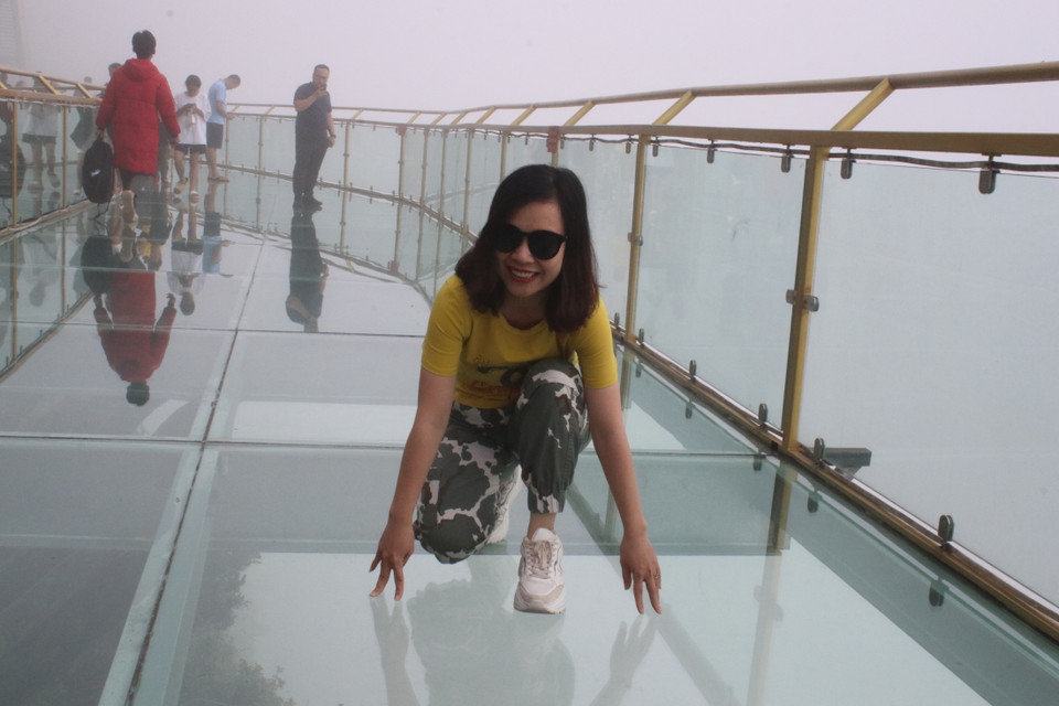 Du khách thích thú trải nghiệm các phong cách trên cầu kính Rồng Mây. (Ảnh: Hùng Võ/Vietnam+)