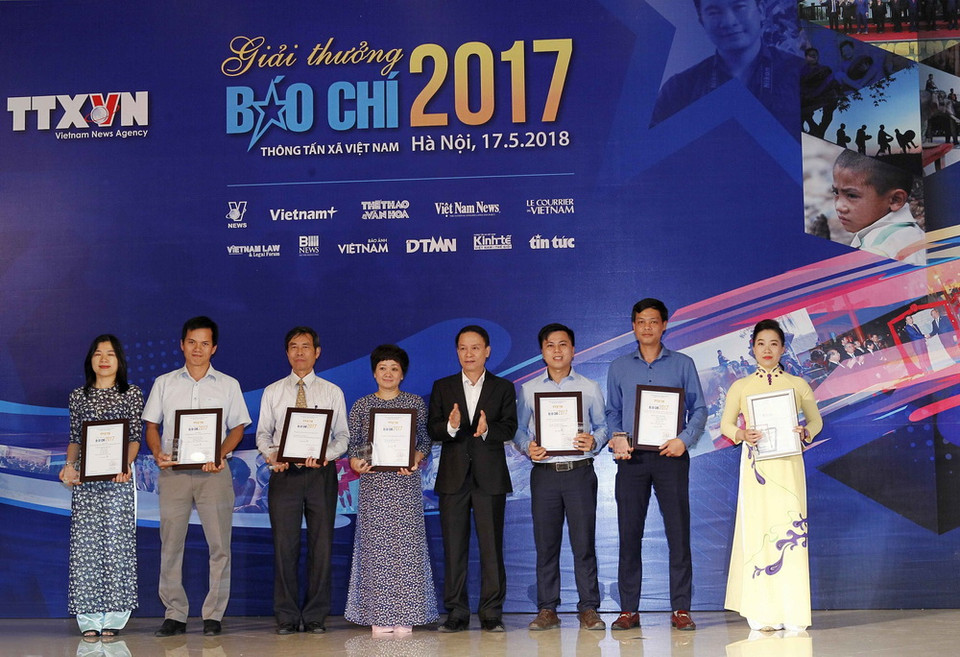 Đồng chí Nguyễn Đức Lợi, Ủy viên BCH Trung ương Đảng, Tổng Giám đốc Thông tấn xã Việt Nam trao giải A cho các tác giả đoạt giải. (Ảnh: Văn Điệp/TTXVN)