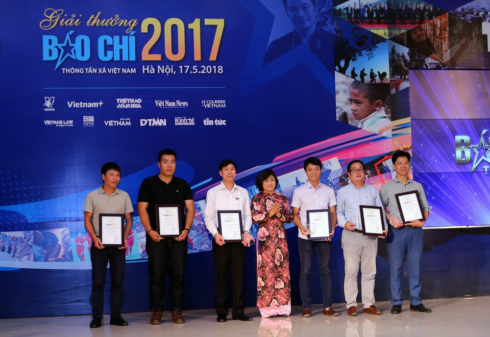 Bà Nguyễn Thu Hà, Phó Chủ tịch Thường trực Liên Chi Hội nhà báo Thông tấn xã Việt Nam, Tổng Biên tập báo Le Courrier Du VietNam, trao giải thể loại Ảnh báo chí cho các tác giả đoạt giải. (Ảnh: Danh Lam/TTXVN)