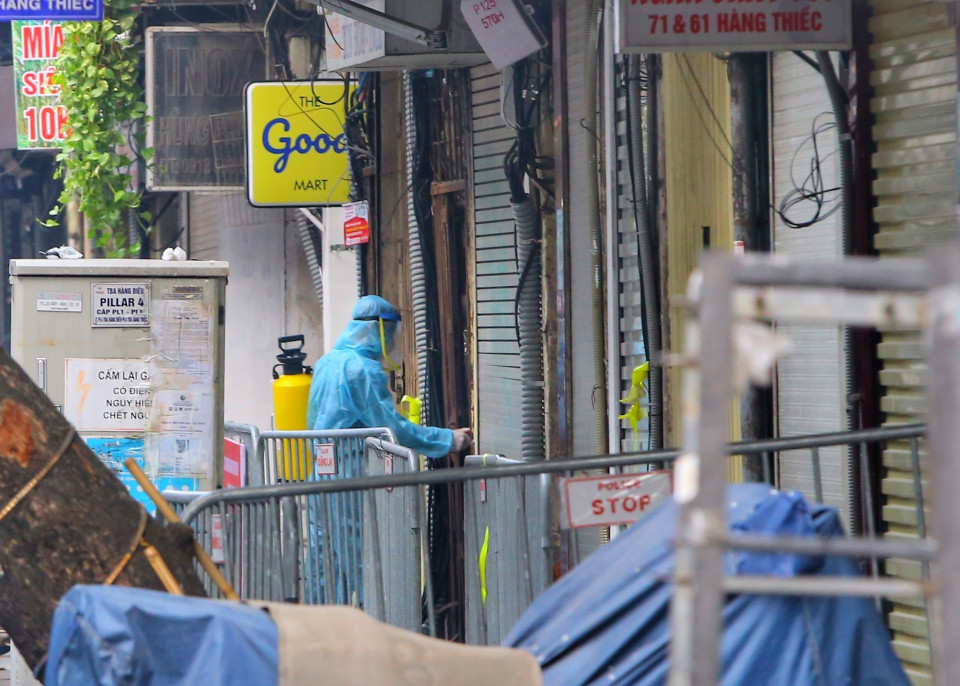 Nhân viên y tế phun khử khuẩn tại các hộ gia đình trên phố Hàng Thiếc (phường Hàng Gai, quận Hoàn Kiếm). (Ảnh: Tuấn Đức/TTXVN)