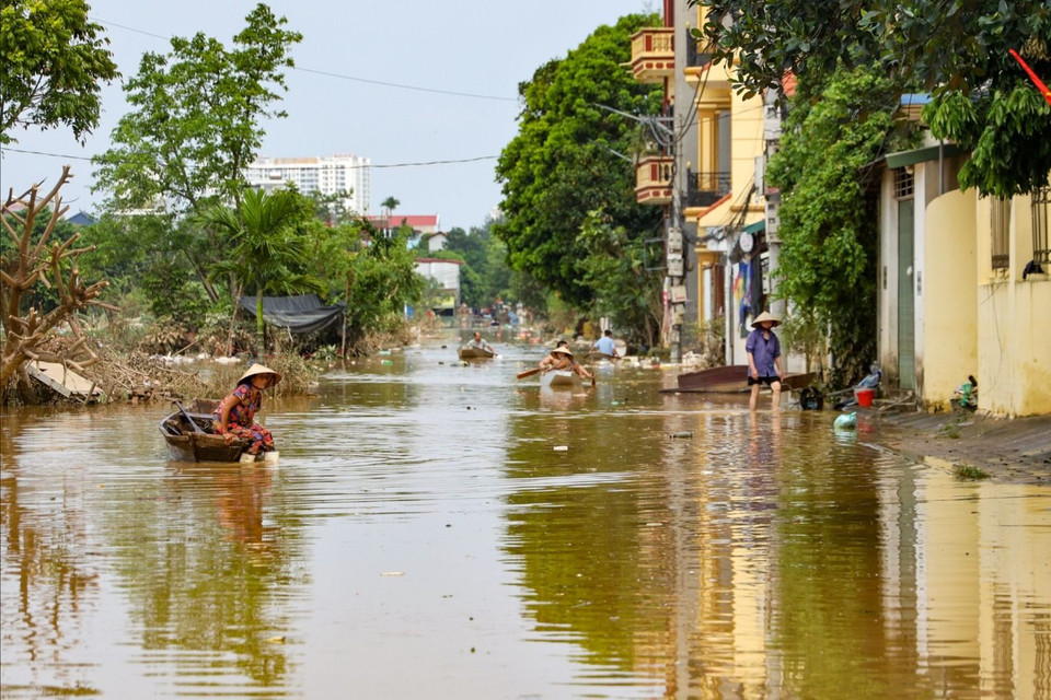 Tuy vậy, các vùng trũng phía sâu bên trong làng bị ngập nặng từ 2-3m nước mới rút 1 phần nên người dân vẫn trong tình trạng chưa thể di chuyển và sinh hoạt như bình thường. (Ảnh: Minh Hiếu/Vietnam+)