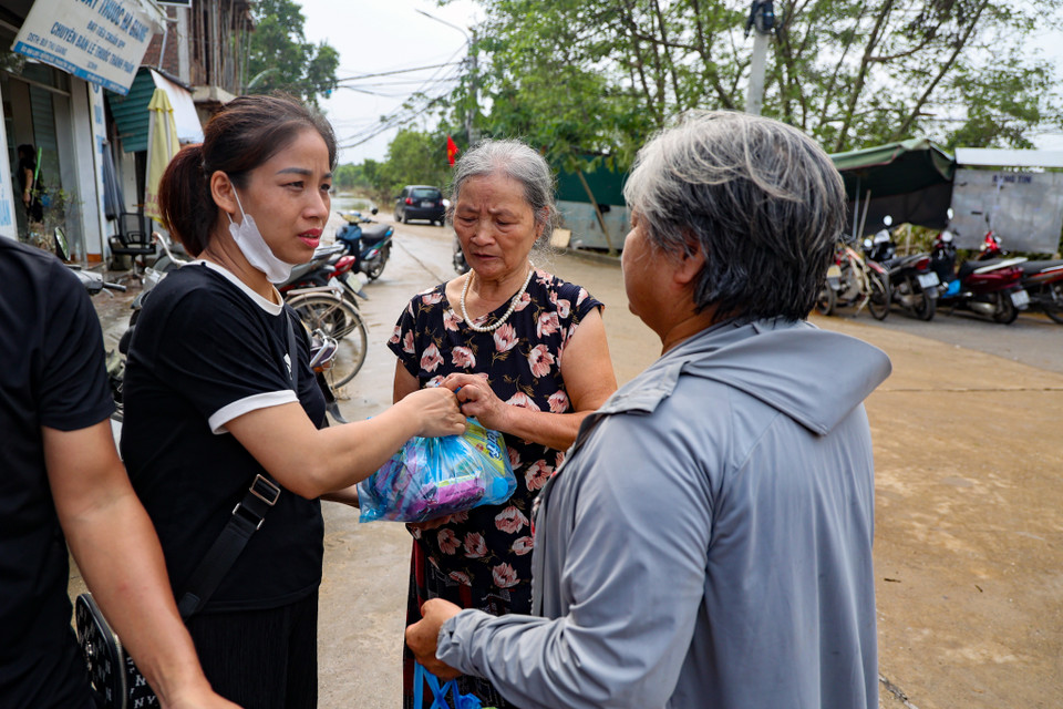 Một số hộ dân đang nhận phần đồ ăn cứu trợ từ các mạnh thường quân. (Ảnh: Minh Hiếu/Vietnam+)
