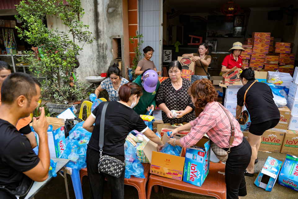 Một số người dân ở các vùng khô ráo đang chuẩn bị các phần đồ ăn, thức uống để tiếp tế, cứu trợ cho người dân trong các vùng còn đang bị ngập úng. (Ảnh: Minh Hiếu/Vietnam+)