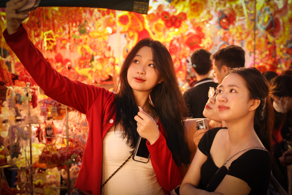 Các bạn trẻ tranh thủ chụp hình, check-in tại con phố đầy màu sắc. (Ảnh: Minh Hiếu/Vietnam+)