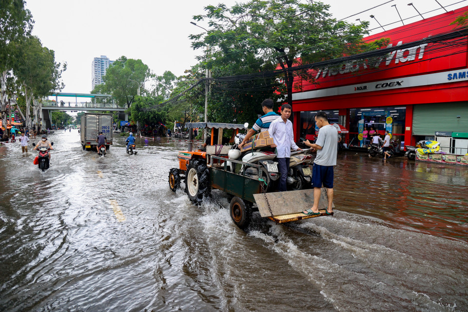 Theo khảo sát, giá cho một chiếc xe di chuyển qua khu vực ngập tại đây là 50.000 đồng/xe. Do đoạn đường ngập khá dài nên nhiều người lựa chọn dịch vụ này. (Ảnh: Minh Hiếu/Vietnam+).