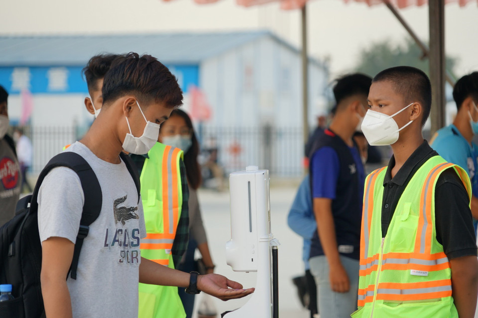 Việc rửa tay sát khuẩn phòng dịch COVID-19 là yêu cầu bắt buộc trước khi vào sân. (Ảnh: Trần Long/TTXVN)