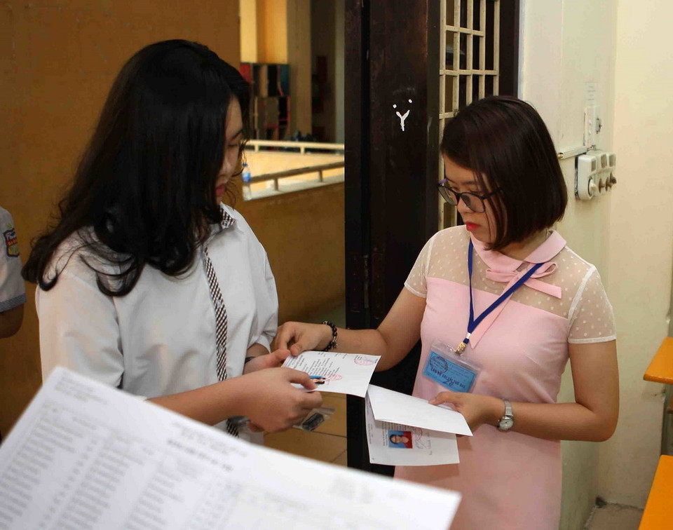 Giám thị coi thi gọi thí sinh vào phòng thi tại điểm thi Trường THPT Phan Đình Phùng. (Ảnh: Thanh Tùng/TTXVN)