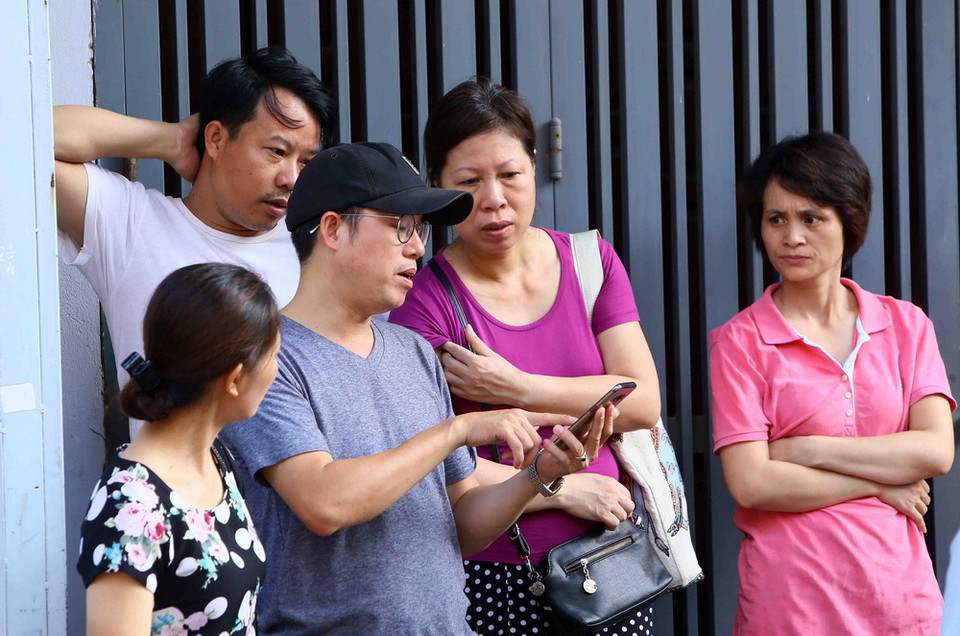  Phụ huynh chờ đợi thí sinh tại hội đồng thi trường THPT Thăng Long, quận Hai Bà Trưng. (Ảnh: Quang Quyết/TTXVN)