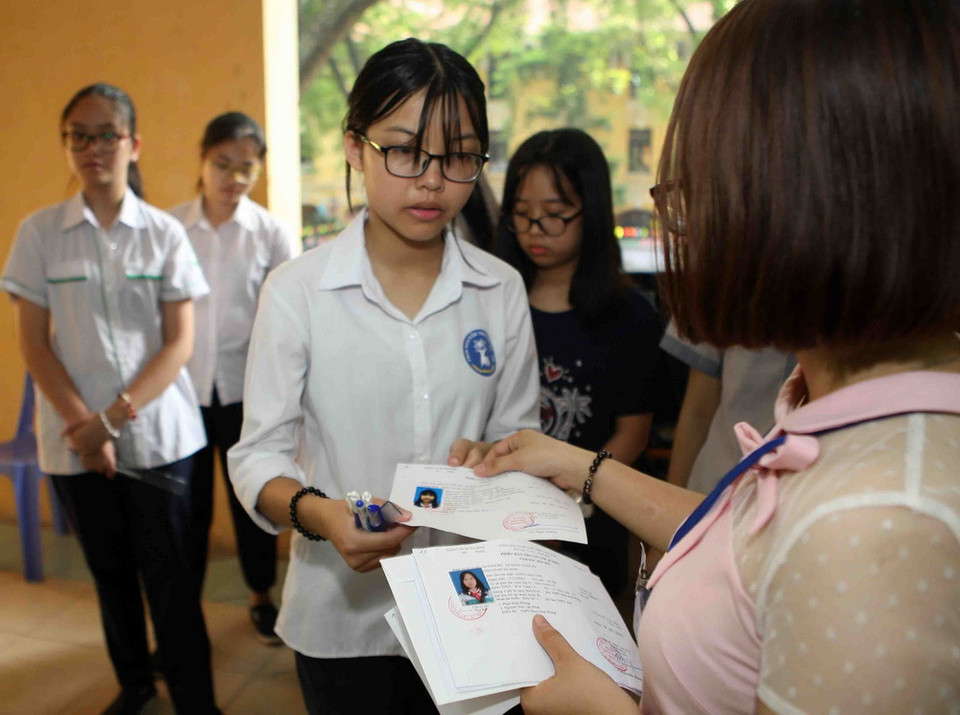 Giám thị coi thi gọi thí sinh vào phòng thi tại điểm thi Trường THPT Phan Đình Phùng. (Ảnh: Thanh Tùng/TTXVN)