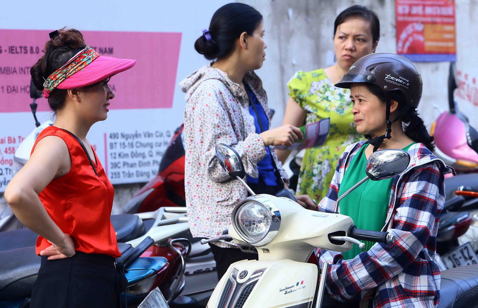  Phụ huynh chờ đợi thí sinh tại hội đồng thi trường THPT Thăng Long, quận Hai Bà Trưng. (Ảnh: Quang Quyết/TTXVN)