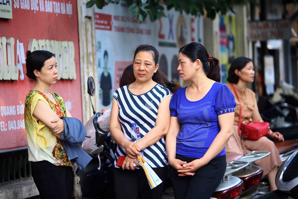  Phụ huynh chờ đợi thí sinh tại hội đồng thi trường THPT Thăng Long, quận Hai Bà Trưng. (Ảnh: Quang Quyết/TTXVN)