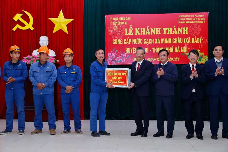 Lãnh đạo huyện Ba Vì tặng quà cho đơn vị thi công đường ống nước sạch tới xã Minh Châu. (Ảnh: Minh Quyết/TTXVN)