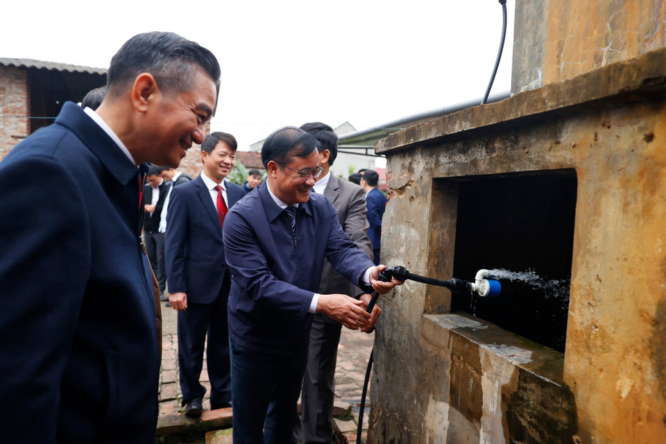 Các đại biểu tham quan một hộ gia đình được sử dụng nước sạch tại xã Minh Châu. (Ảnh: Minh Quyết/TTXVN)