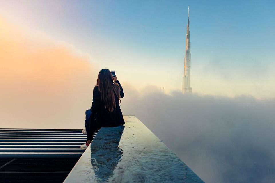 Trên tầng mây. Phía xa là tòa tháp cao nhất thế giới Burj Khalifa của Dubai. (Nguồn: NatGeo)