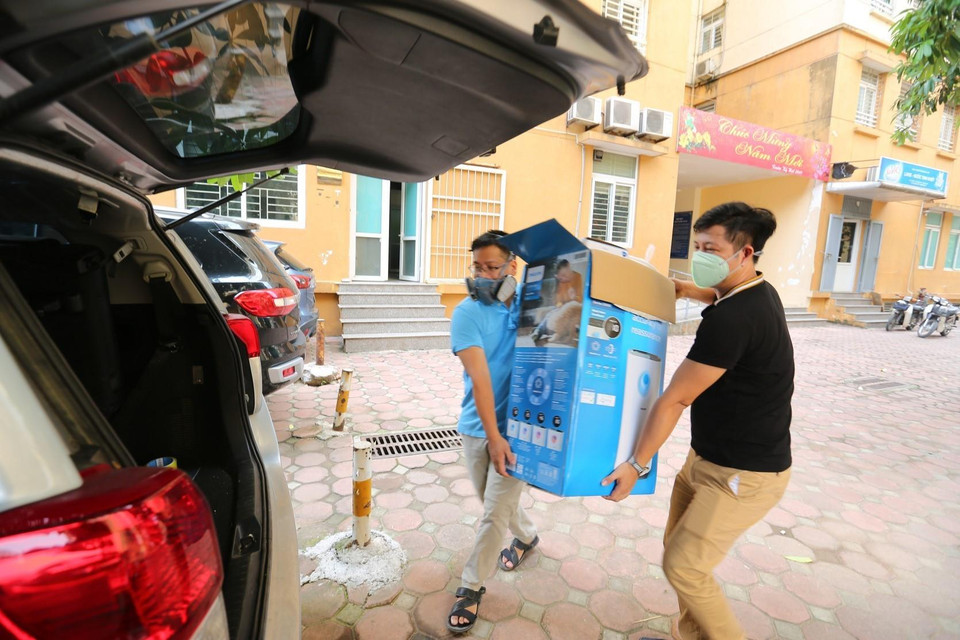 Người dân cẩn thận đeo mặt nạ chống độc khi chuyển đồ đạc. (Ảnh: Thành Đạt/TTXVN)