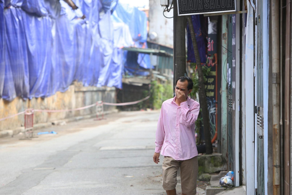 Người dân lấy tay che mặt mỗi khi đi qua khu vực cháy. (Ảnh: Thành Đạt/TTXVN)