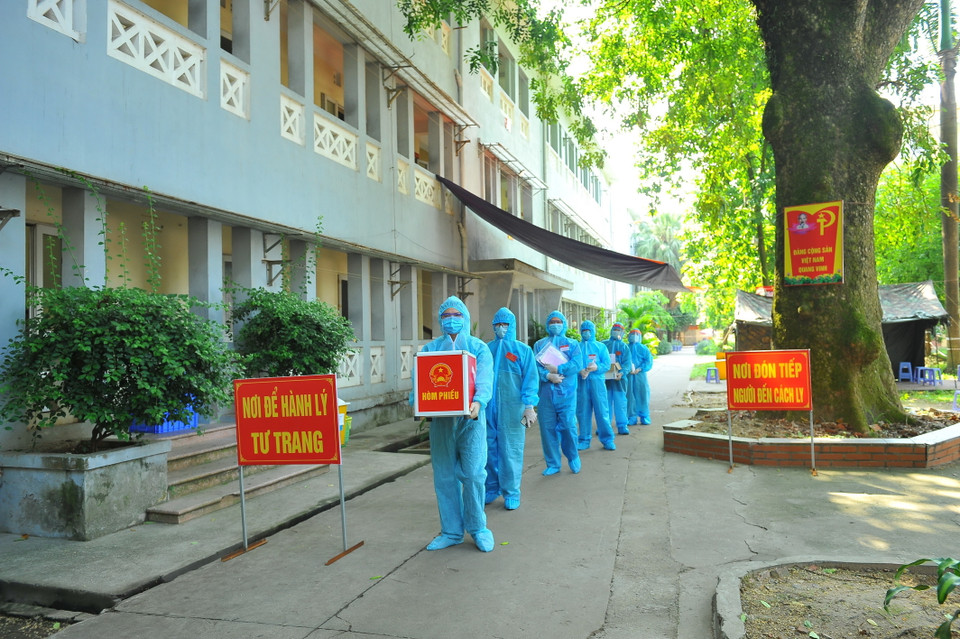 Lực lượng chức năng mang hòm phiếu đến từng phòng để cử tri thực hiện quyền bầu cử, tại đơn vị bầu cử số 7, phường Trang Hạ, thị xã Từ Sơn. (Ảnh: Minh Đức/TTXVN)