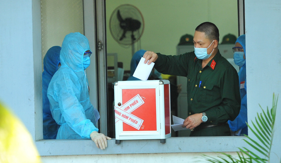 Các cử tri làm nhiệm vụ tại Khu cách ly tập trung, bỏ phiếu bầu tại đơn vị bầu cử số 7, phường Trang Hạ, thị xã Từ Sơn. (Ảnh: Minh Đức/TTXVN)