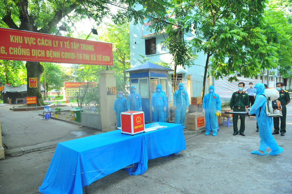 Lực lượng chức năng phun khử khuẩn khu vực bỏ phiếu bầu, tại đơn vị bầu cử số 7, Khu cách ly trong Trường Đại học Thể dục Thể thao, phường Trang Hạ, thị xã Từ Sơn. (Ảnh: Minh Đức/TTXVN)