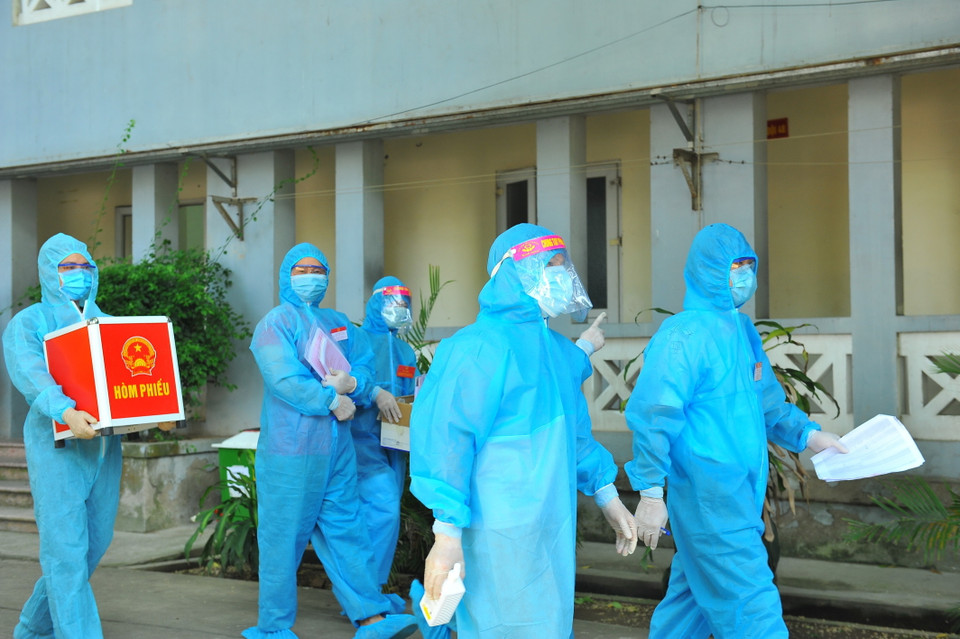 Lực lượng chức năng mang hòm phiếu đến từng phòng để cử tri thực hiện quyền bầu cử, tại đơn vị bầu cử số 7, phường Trang Hạ, thị xã Từ Sơn. (Ảnh: Minh Đức/TTXVN)