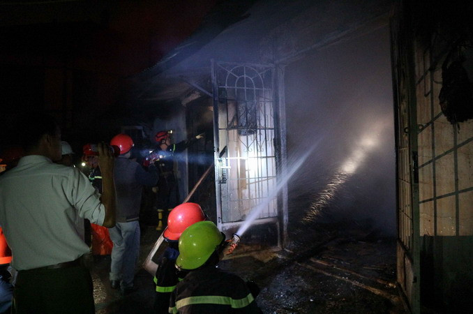 Hàng chục chiến sỹ cảnh sát phun nước khống chế ngọn lửa tại khu nhà số 13 Trần Hưng Đạo. (Ảnh: Nguyễn Dũng/TTXVN)