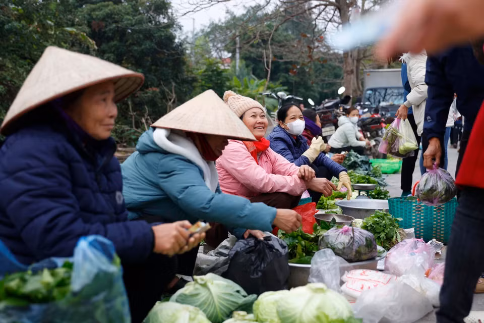 Phía ngoài cổng đình và hai bên đường có hàng trăm người bày bán hàng hóa, các vật phẩm thiết yếu và những món hàng may mắn cho năm mới. (Ảnh: Minh Quyết/TTXVN)