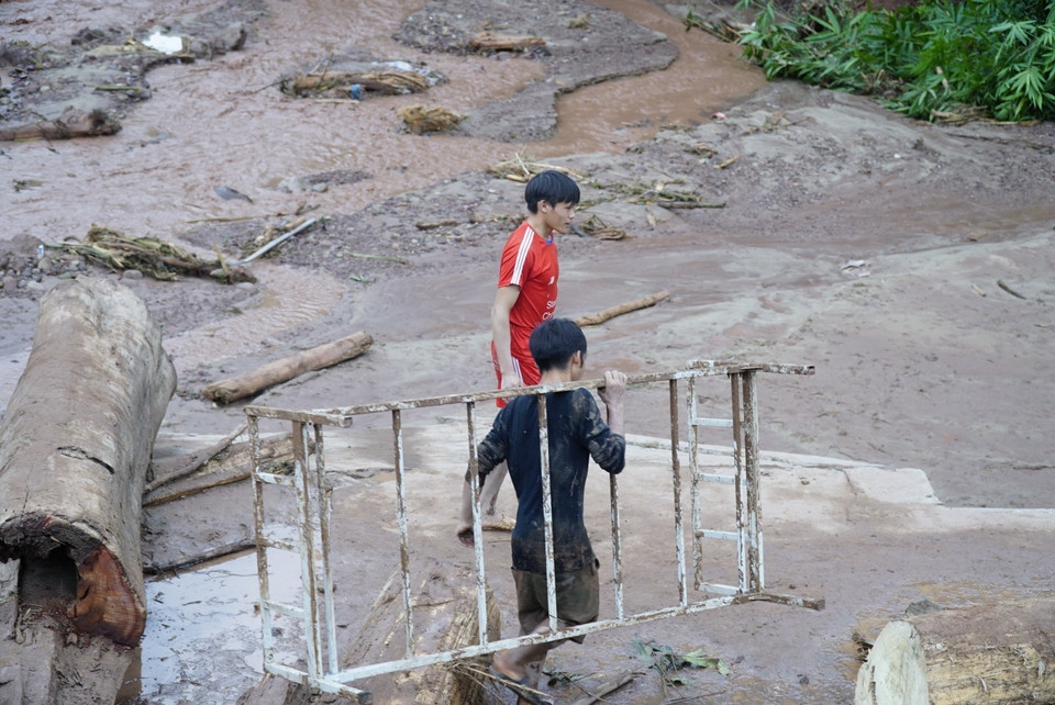 Người dân thu gom đồ đạc sau lũ. (Ảnh: Xuân Tư/TTXVN)