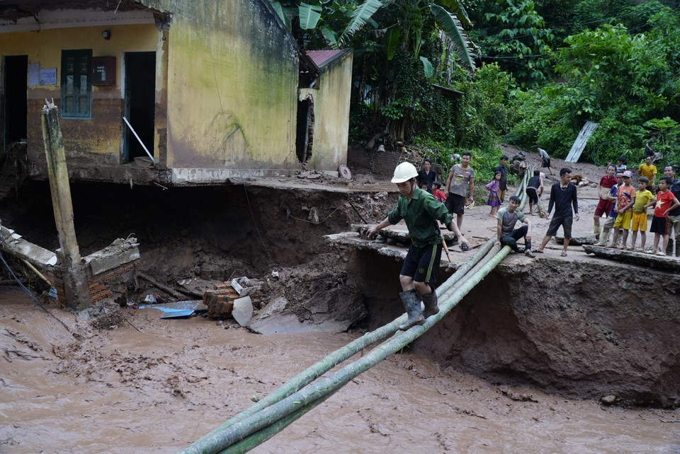 Việc đi lại của người dân sau lũ rất khó khăn. (Ảnh: Xuân Tư/TTXVN)