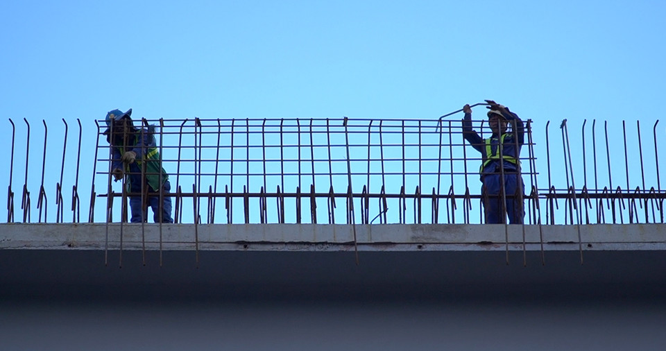 Hình ảnh công nhân đang hoàn thiện những mảng lan can cầu cạn tại gần siêu thị Metro. (Nguồn: Vietnam+)