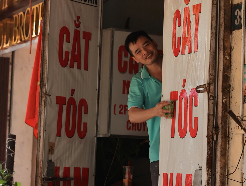 Người dân phố Cầu Đất (quận Hoàn Kiếm) lau dọn nhà cửa sau khi nước rút (ảnh chụp lúc 8h45).(Ảnh: Hoàng Hiếu/TTXVN)