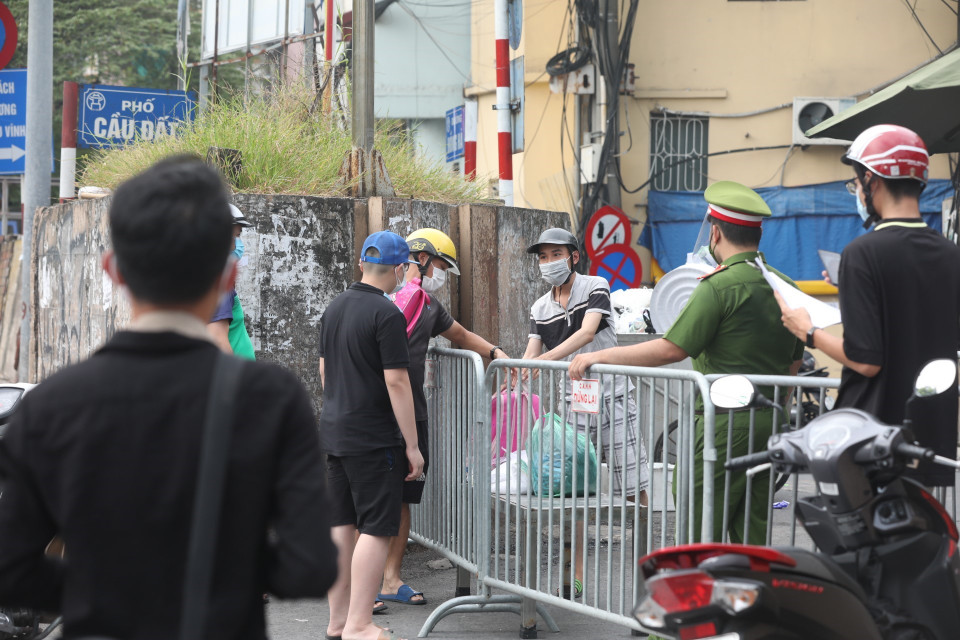 Người dân tiếp tế lương thực, đồ dùng thiết yếu cho người trong khu cách ly. (Ảnh: Minh Quyết/TTXVN)