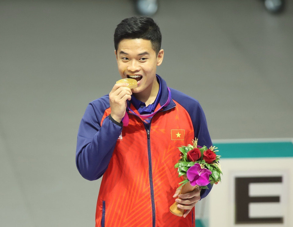 Xạ thủ Phạm Quang Huy ăn mừng trên bục nhận huy chương Vàng tại ASIAD 19. (Ảnh: TTXVN phát)
