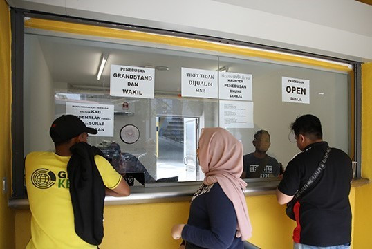 Các cổ động viên may mắn mua được vé tại điểm bán vé sân Bukit Jalil (Kuala Lumpur). (Ảnh: Hoàng Linh/TTXVN)