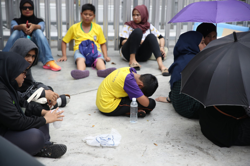 Trẻ nhỏ cũng bị cuốn vào cơn sốt vé của người lớn. (Ảnh: Hoàng Linh/TTXVN)