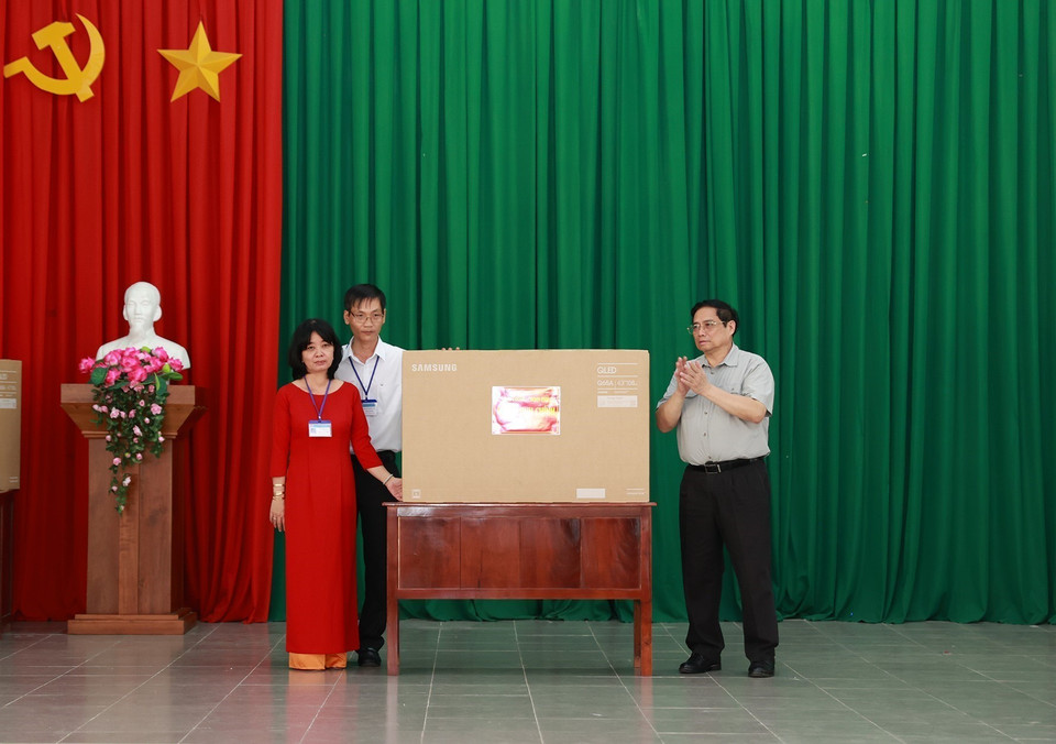 Thủ tướng Phạm Minh Chính tặng quà cho giáo viên Trường nuôi dạy trẻ em khuyết tật Bến Tre. (Ảnh: Dương Giang/TTXVN)