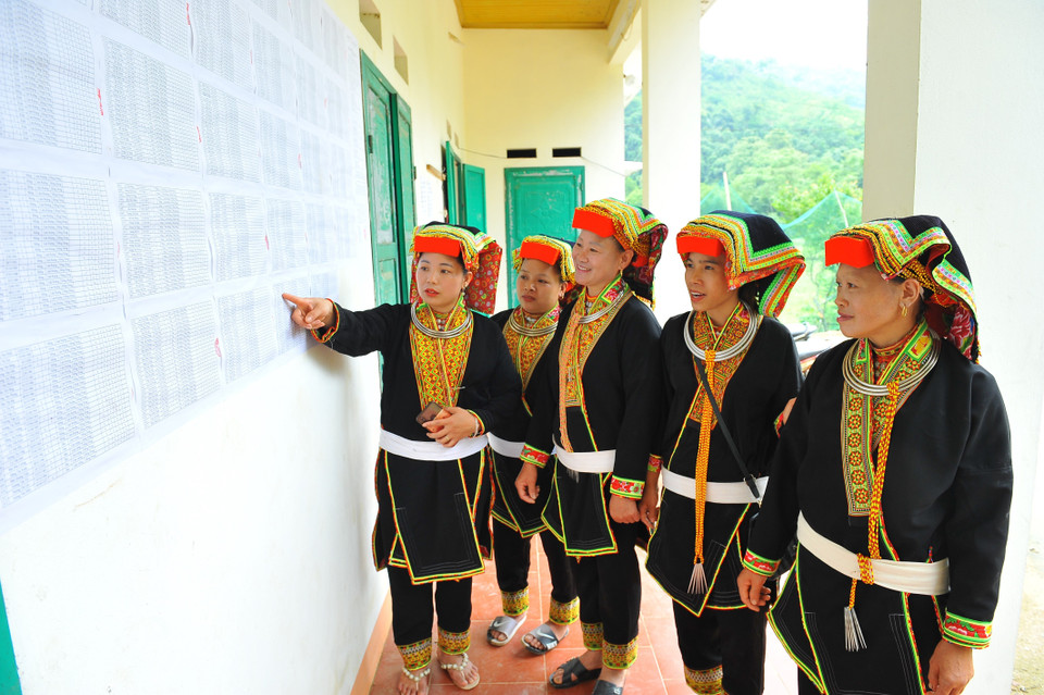 Bà con dân tộc Dao xem danh sách cử tri tham gia bầu cử đại biểu Quốc hội khóa XV và bầu cử đại biểu hội đồng nhân dân các cấp nhiệm kỳ 2021-2026 được niêm yết tại khu vực bỏ phiếu số 7 thuộc xã Phương Giao, huyện Võ Nhai, tỉnh Thái Nguyên. (Ảnh: Minh Đức/TTXVN)