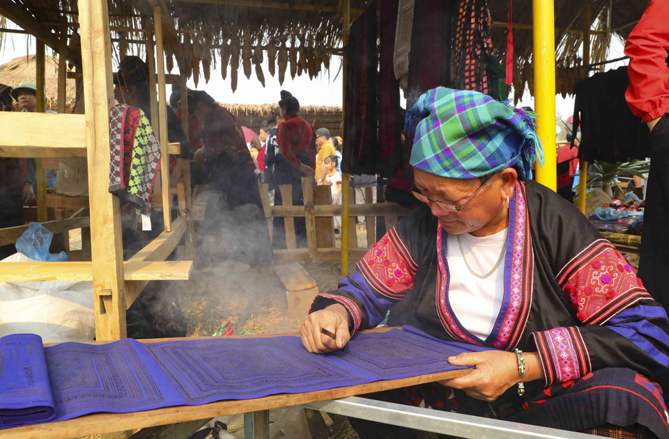 Trình diễn nghệ thuật tạo hoa văn trên trang phục truyền thống người dân tộc Mông tại Không gian văn hóa vùng cao. (Ảnh: Trung Kiên/TTXVN)