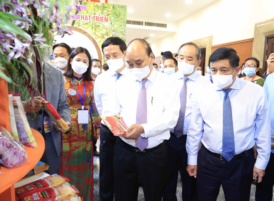 Chủ tịch nước Nguyễn Xuân Phúc thăm khu trưng bày các sản phẩm tiêu biểu của huyện Hóc Môn và Củ Chi. (Ảnh: Thống Nhất/TTXVN)