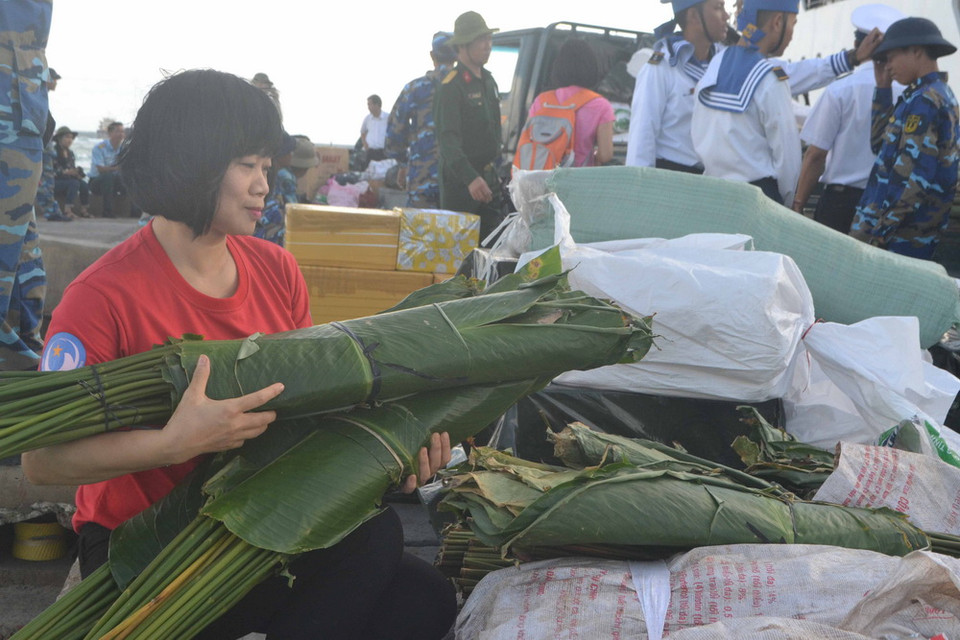 Đại diện Câu lạc bộ Tuổi trẻ vì biển đảo Tổ quốc tặng lá dong và nhiên liệu gói bánh chưng cho cán bộ chiến sỹ đảo Đá Lát, quần đảo Trường Sa (Khánh Hòa). (Ảnh: Đoàn Hữu Trung/TTXVN)