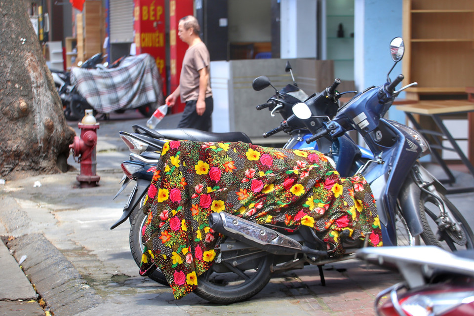 Xe máy được phủ khăn lên yên để chống nóng. (Ảnh: Tuấn Đức/TTXVN)