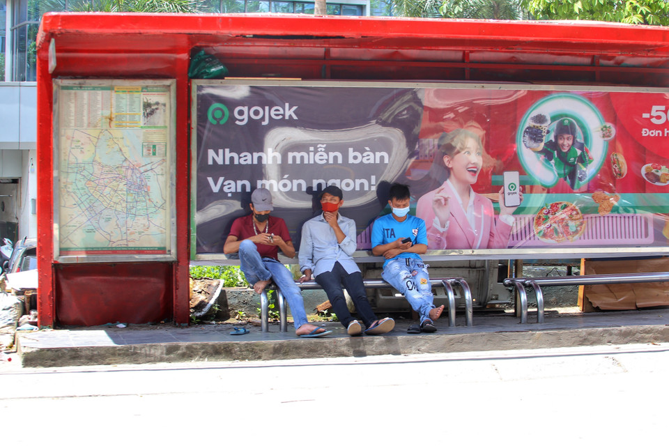 Trạm dừng xe buýt là nơi người dân tránh nắng nóng gay gắt. (Ảnh: Tuấn Đức/TTXVN)