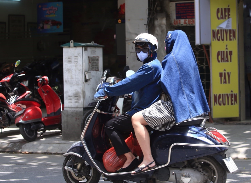 Khoác áo là một cách chống nắng tạm thời được nhiều người ưa thích khi phải ra ngoài trời. (Ảnh: Hoàng Hiếu/TTXVN)