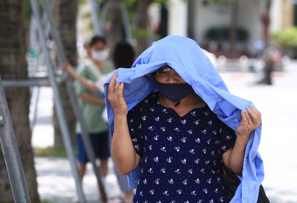 Người dân phải che chắn khi đi ra ngoài trời. (Ảnh: Hoàng Hiếu/TTXVN)