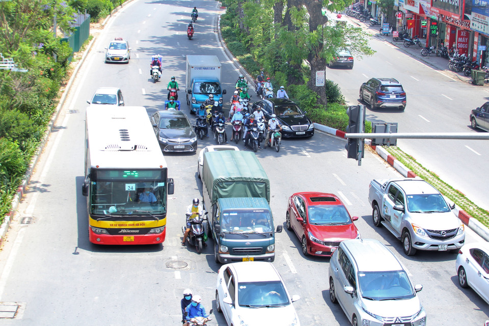 Nhiều người tham gia giao thông đứng tránh nắng mỗi khi có đèn đỏ. (Ảnh: Tuấn Đức/TTXVN)