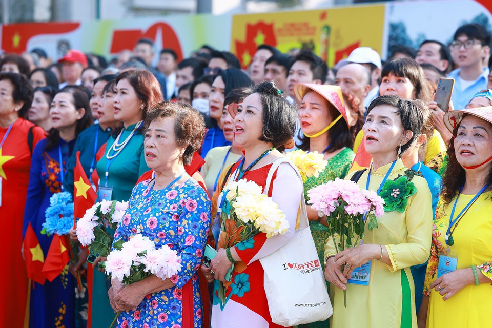 Quần chúng nhân dân chào cờ, hát quốc ca tái hiện lại buổi lễ chào cờ đầu tiên tại Hà Nội vào ngày 10/10/1954. (Ảnh: Dương Giang/TTXVN)